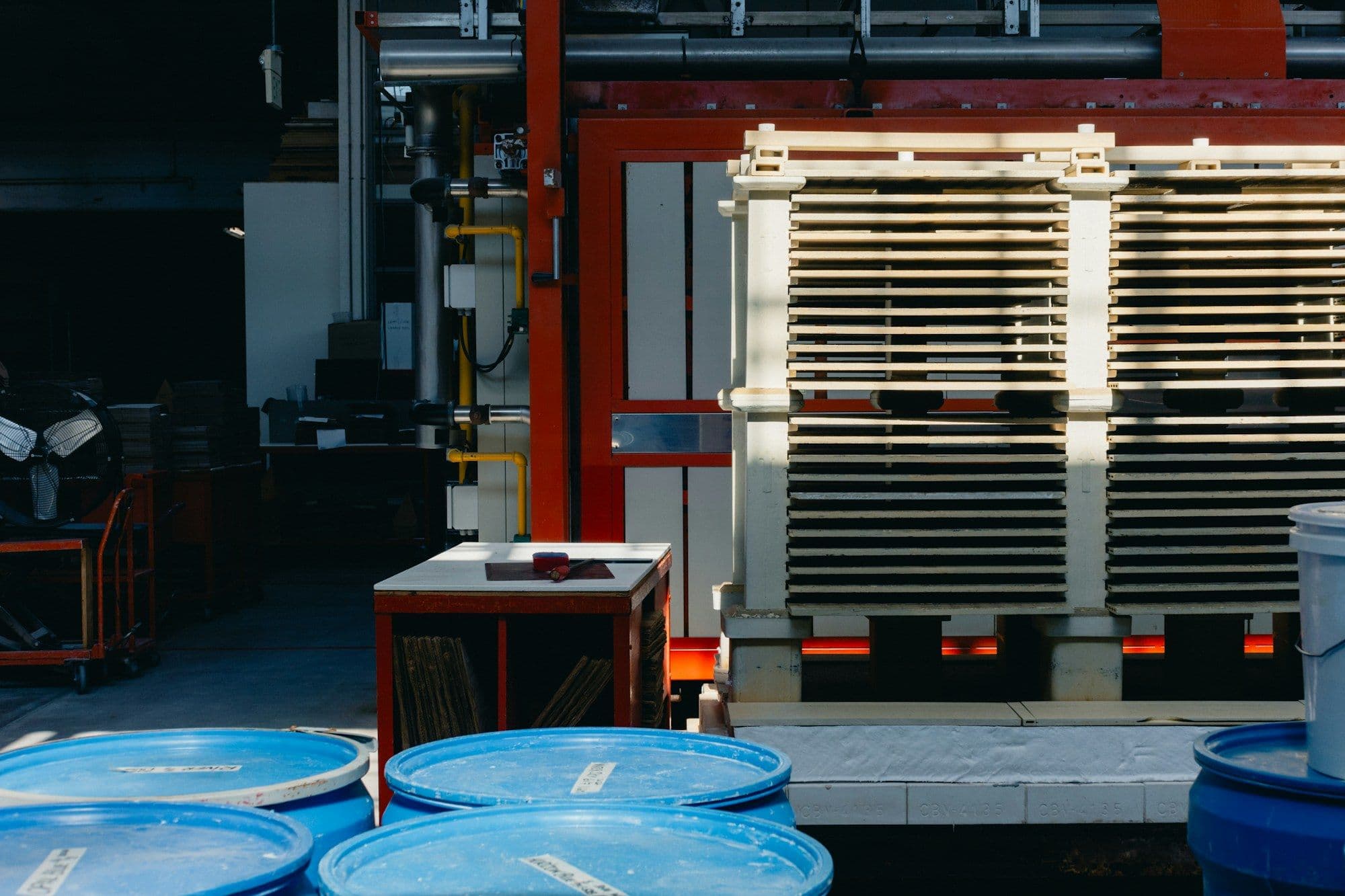 Blue HDPE cleaner drums in front of an industrial unit in a warehouse