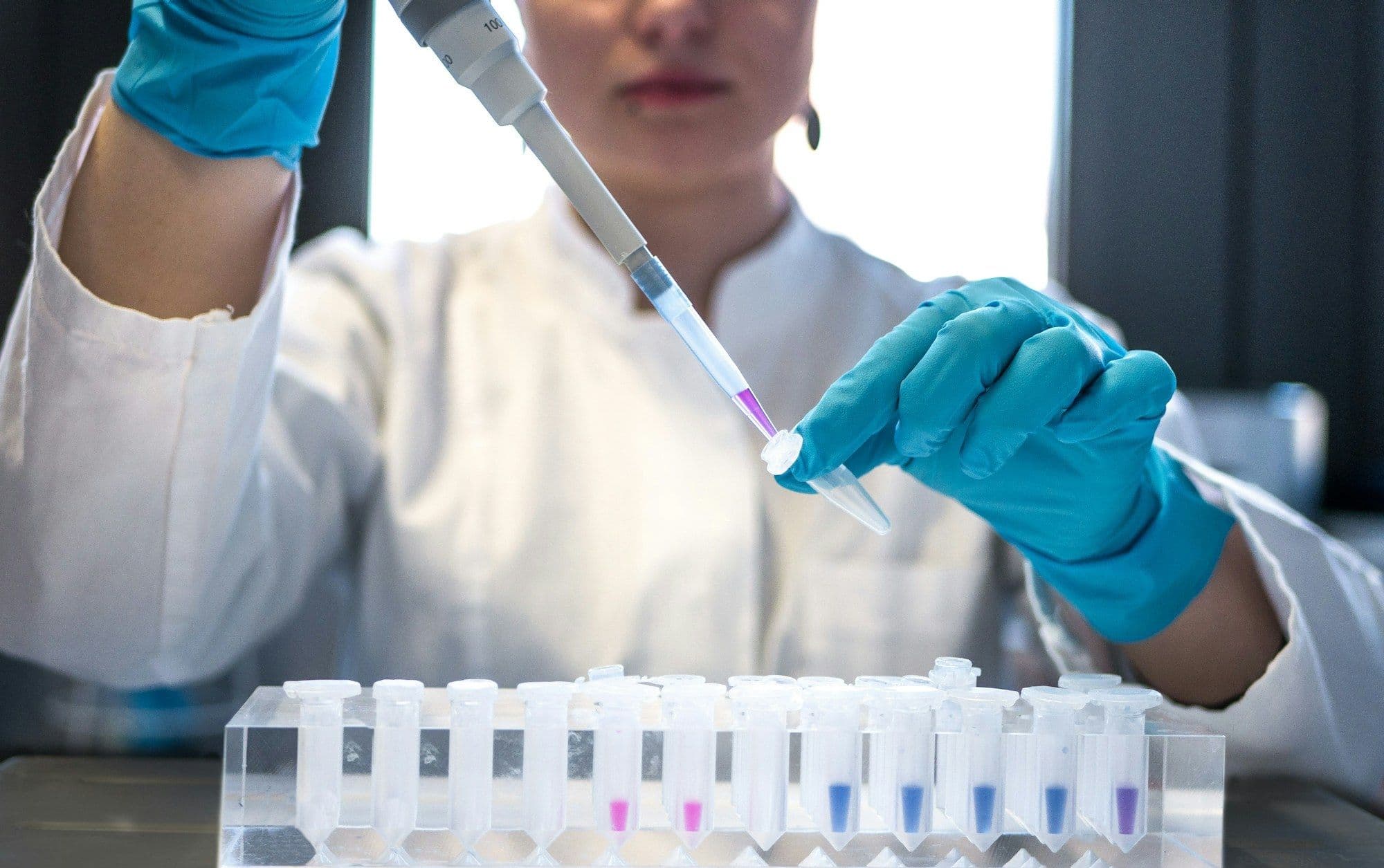 Chemist pipetting an aqueous sample into test vials for pH and solids testing.