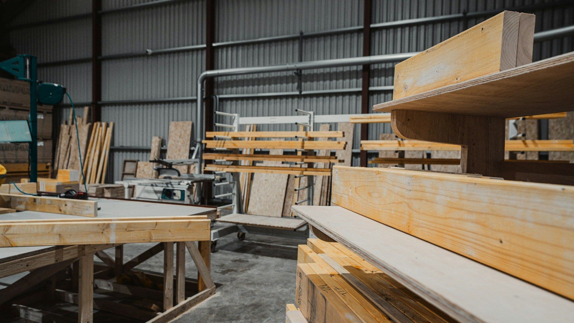 Panel furniture workshop with stacks of cut boards and timber