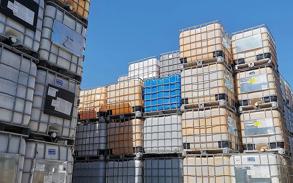 Chemical IBC tote containers stacked on warehouse pallet racks for local bottling