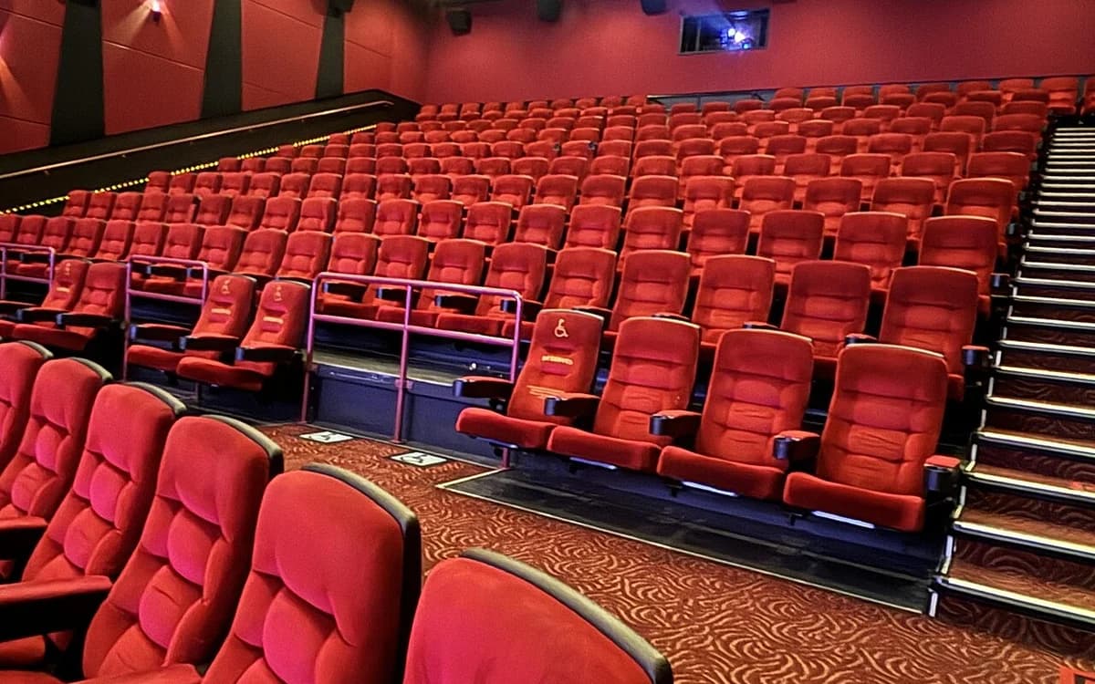 Interior of a modern movie theater auditorium with tiered rows of plush reclining seats