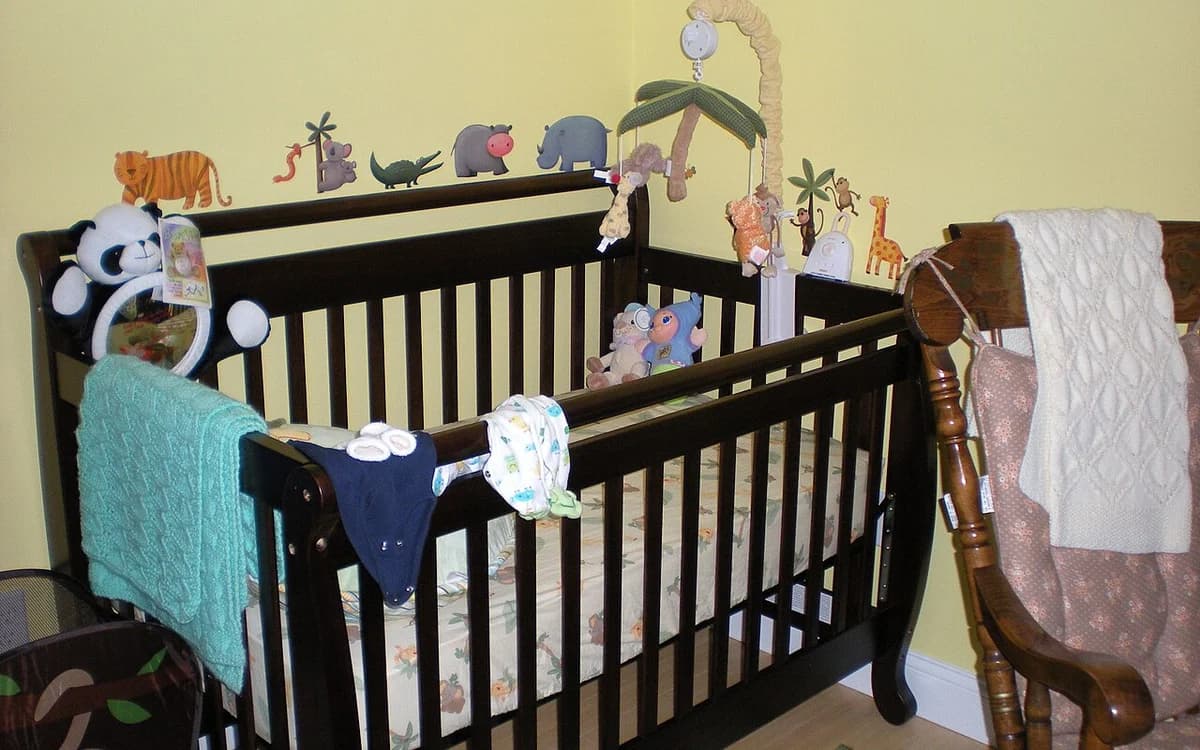 Wooden baby crib bed inside a bright residential nursery room