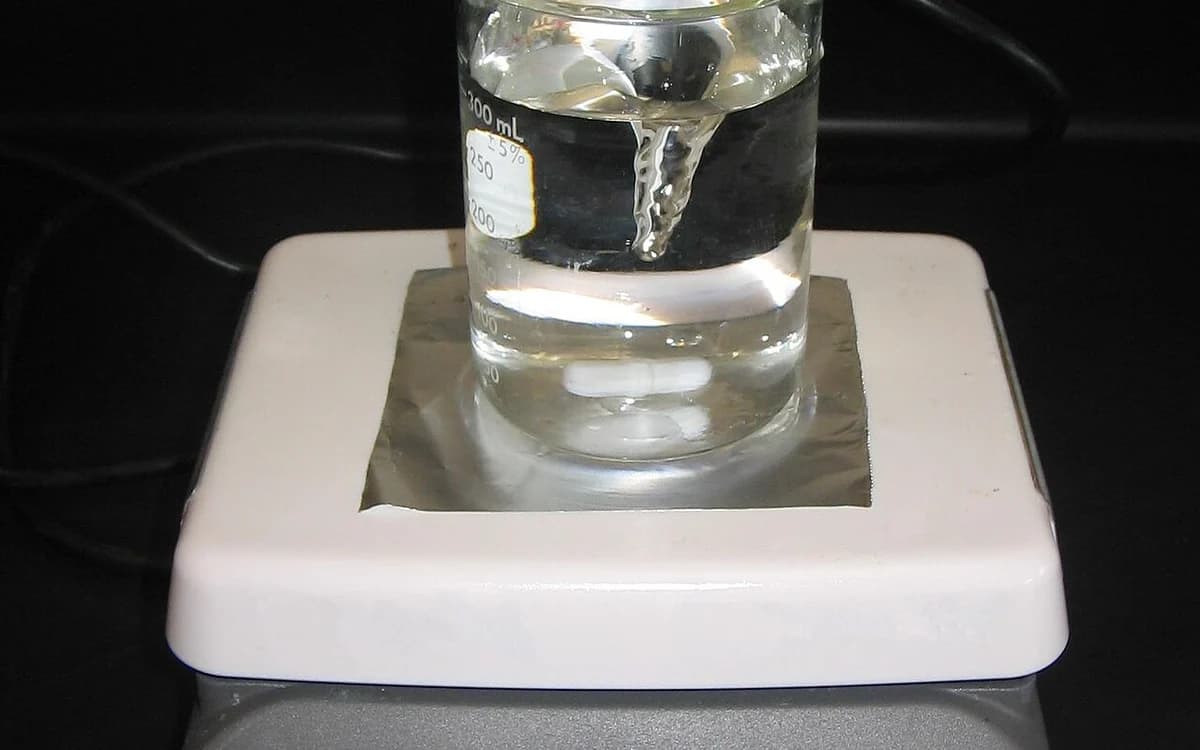 Laboratory beaker on a magnetic stirrer during controlled low-shear colloidal dilution