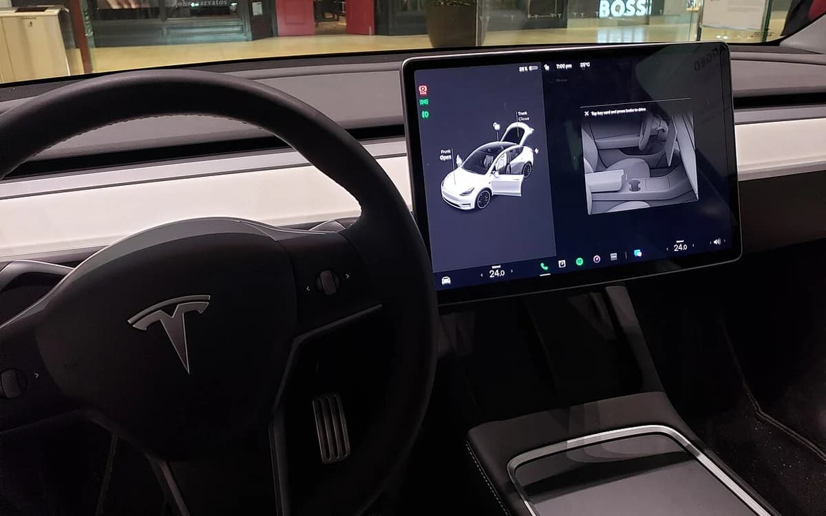 Electric vehicle cabin interior with panoramic glass roof and center touchscreen