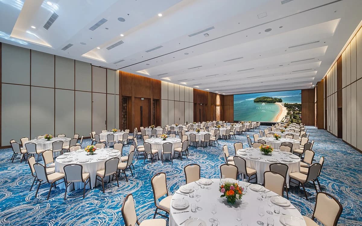 Luxury hotel grand ballroom with high ceilings, chandeliers, and carpeted floor