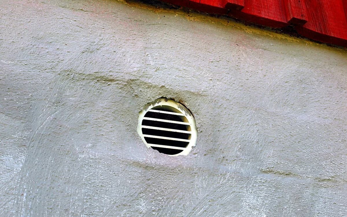 Commercial ceiling air conditioning vent and fan-coil return grille inside a hotel room