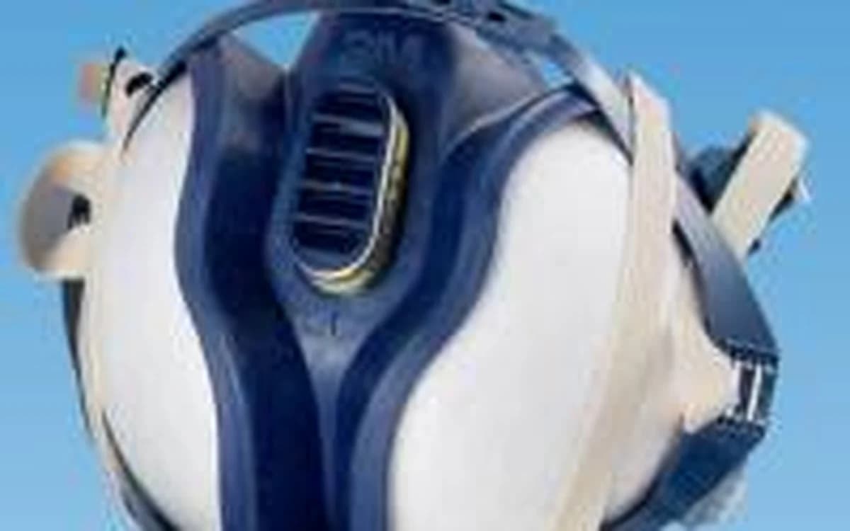 IAQ technician wearing twin-cartridge respirator mask and sealed safety goggles PPE
