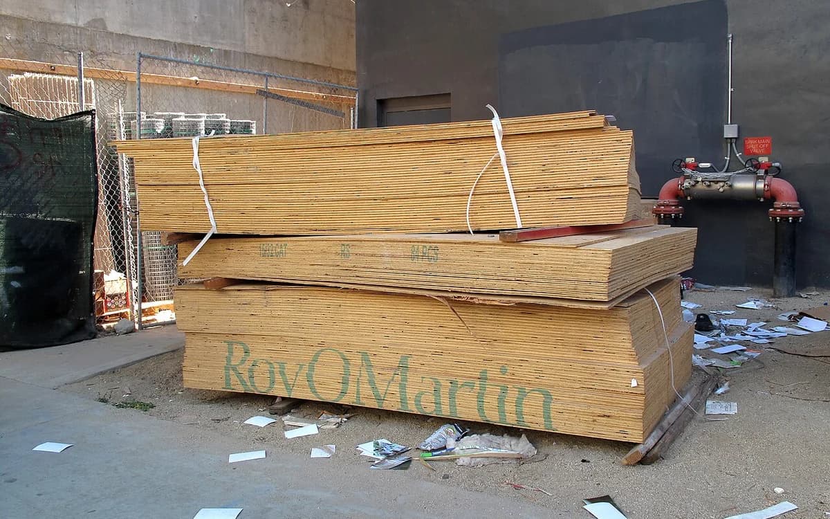 Stacked plywood and composite wood panels on an industrial mill production floor ready for inline conditioning
