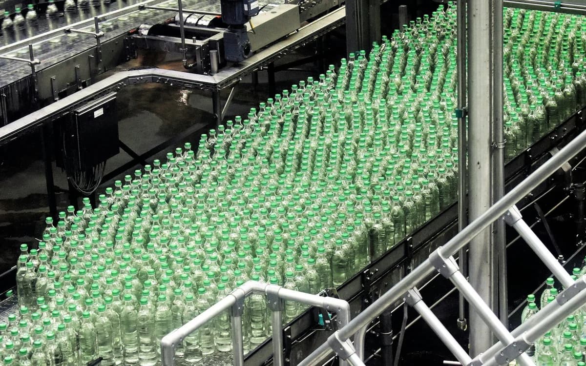 Rotary bottling and capping conveyor line inside a beverage and liquid packaging plant