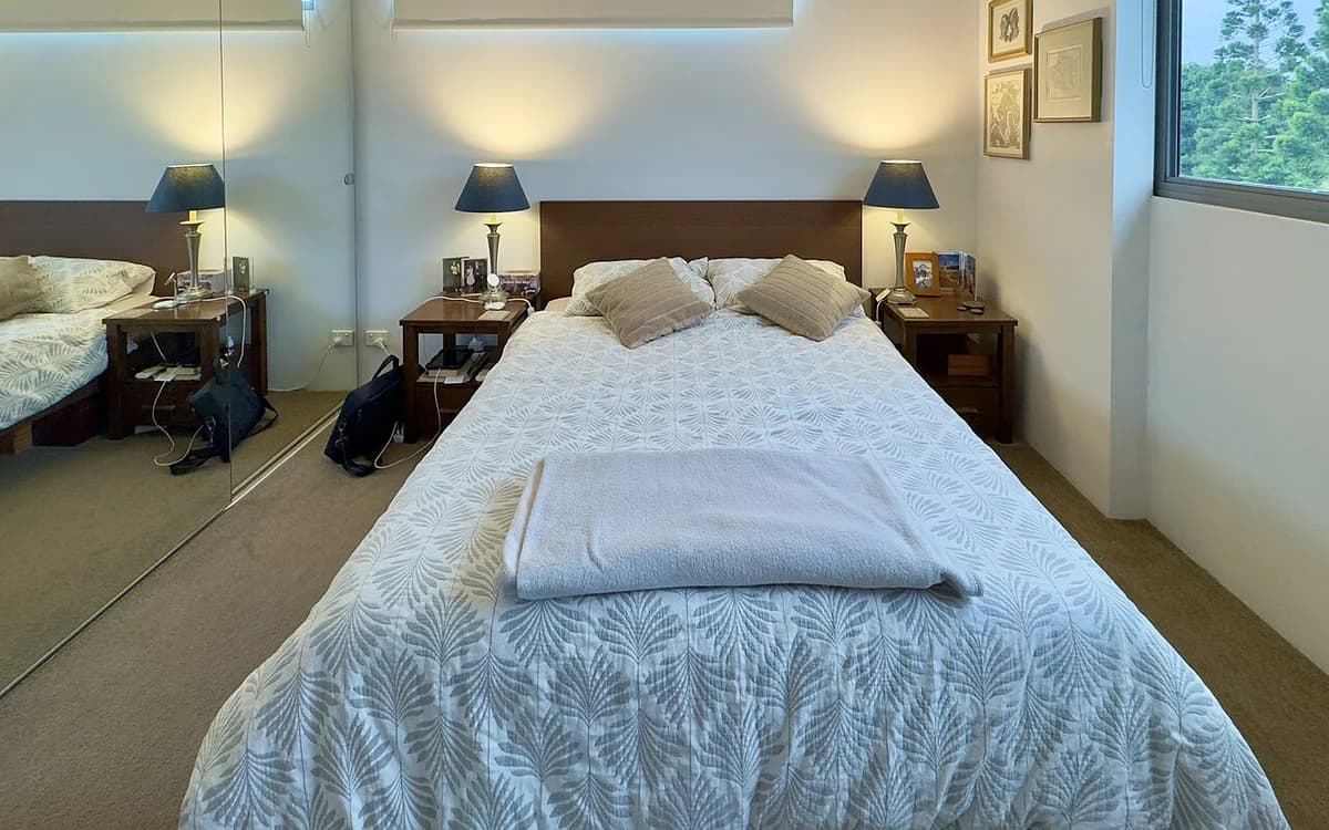 Furnished apartment bedroom with built-in wardrobe and bed frame
