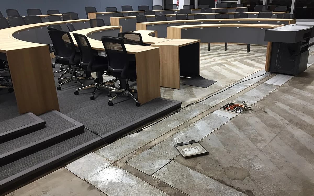 Water-damaged commercial seminar room floor requiring emergency restoration