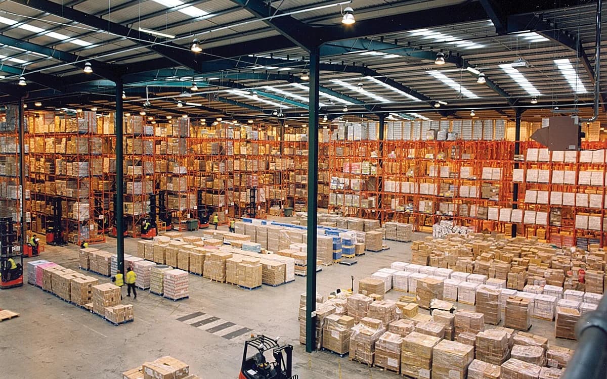 Palletized export furniture cartons stored on high-bay warehouse racks prior to container loading
