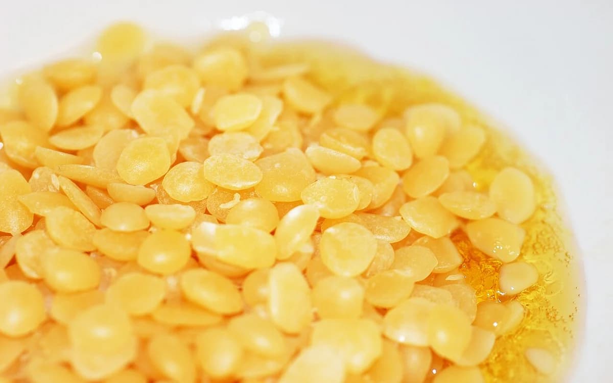 Golden natural beeswax blocks melting for traditional wood conditioning