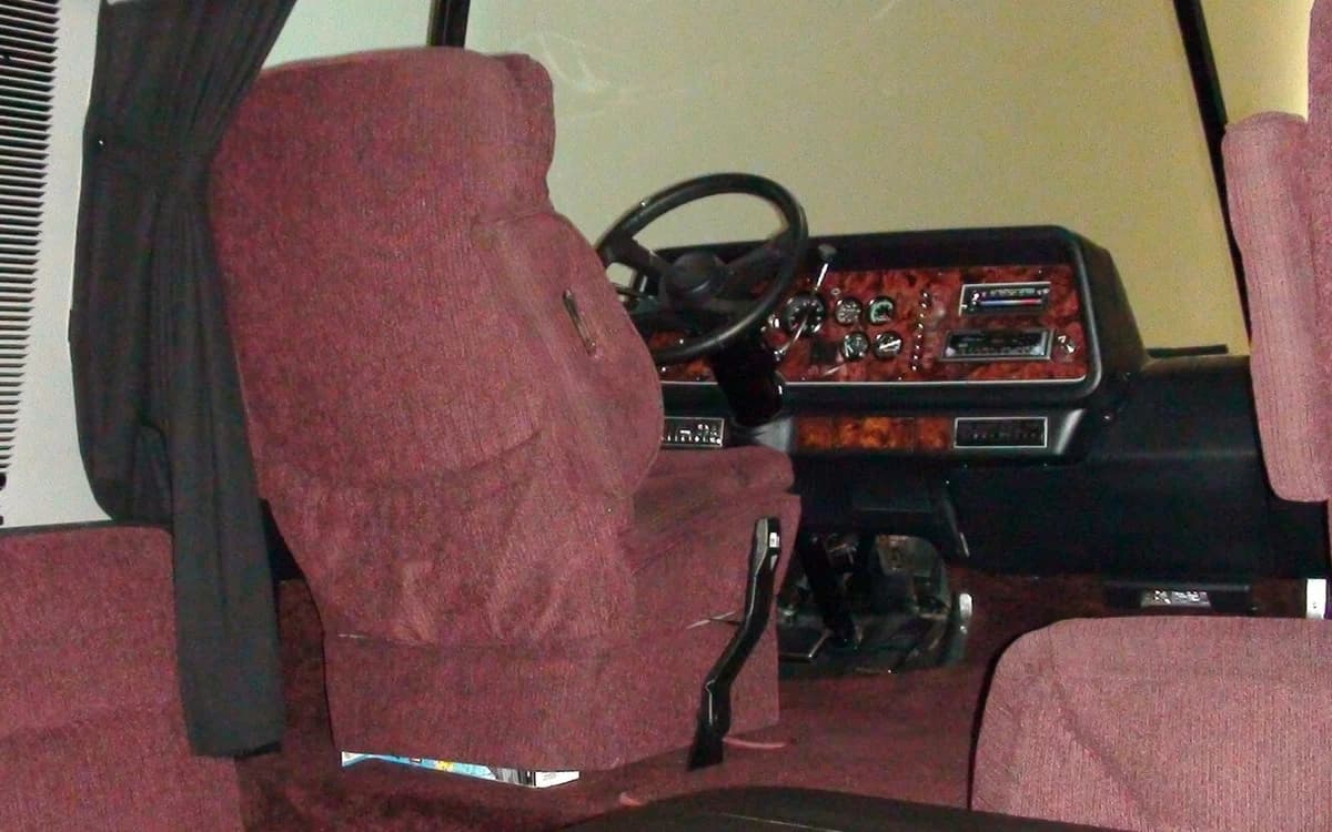 RV motorhome camper interior showing overhead poplar plywood galley cabinets and dinette
