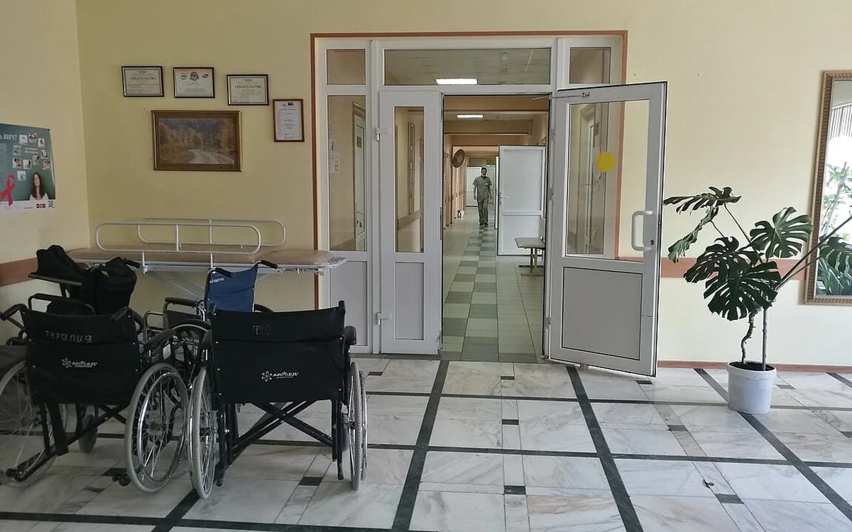 Inpatient hospital and senior care ward with beds and vinyl flooring