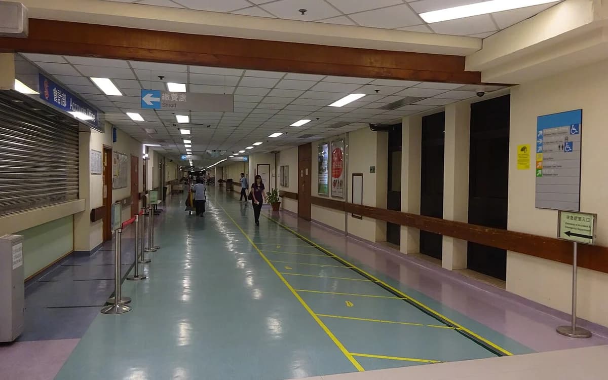 Windowless hospital ground floor interior corridor lit only by ceiling LED fixtures