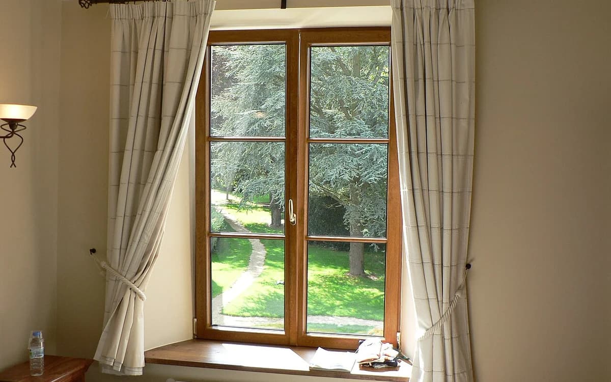 Window draperies and curtains treated with thermal steam fumigation to remove textile finishing resins