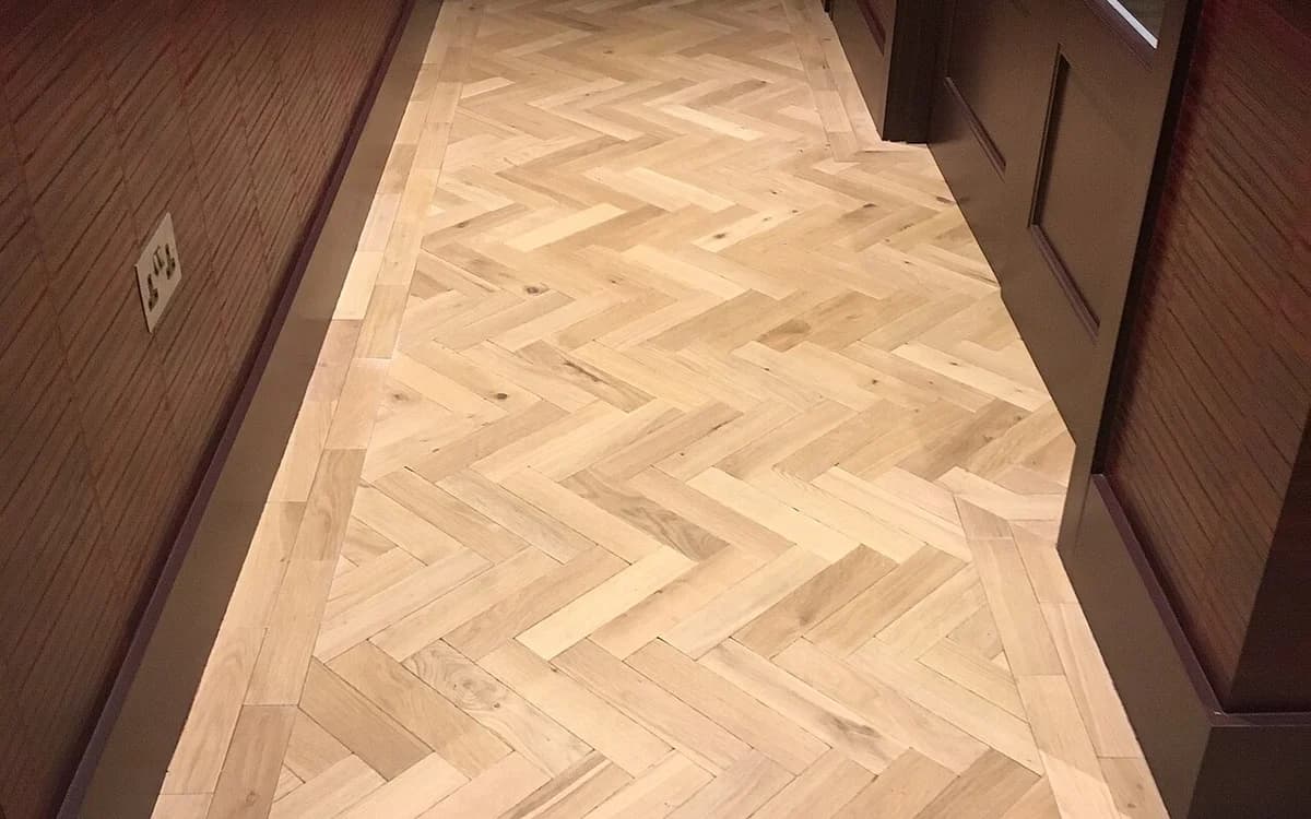 Close-up of engineered parquet wood flooring planks and tongue-and-groove seam lines